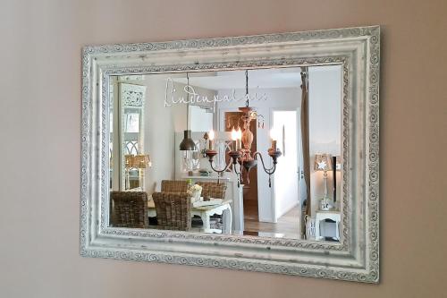 een spiegel met een wit frame aan een muur bij Linden-Palais Wohnung 12 in Heiligendamm