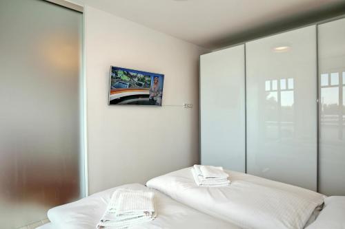 ein Schlafzimmer mit einem Bett und einem Bild an der Wand in der Unterkunft Linden-Palais Wohnung 16 in Heiligendamm