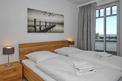 1 Schlafzimmer mit 2 Betten und Blick auf einen Pier in der Unterkunft Linden-Palais Wohnung 16 in Heiligendamm