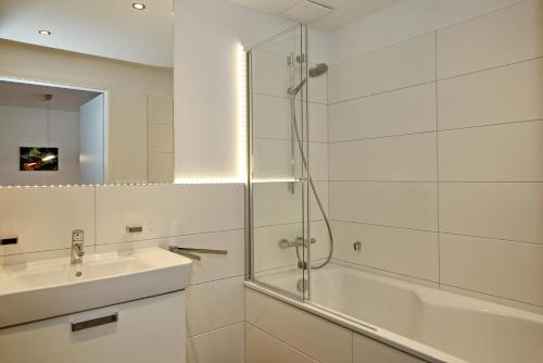 ein Bad mit einer Glasdusche und einem Waschbecken in der Unterkunft Linden-Palais Wohnung 02 in Heiligendamm