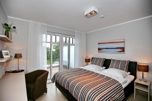 ハイリゲンダムにあるLinden-Palais Wohnung 37のベッドルーム1室(ベッド1台、椅子、窓付)