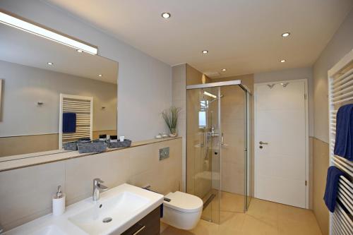 La salle de bains est pourvue d'une douche, d'un lavabo et de toilettes. dans l'établissement Linden-Palais Wohnung 37, à Heiligendamm