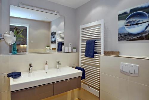 a bathroom with a white sink and a mirror at Linden-Palais Wohnung 15 in Heiligendamm