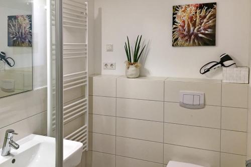 een witte badkamer met een wastafel en een spiegel bij Linden-Palais Wohnung 07 in Heiligendamm