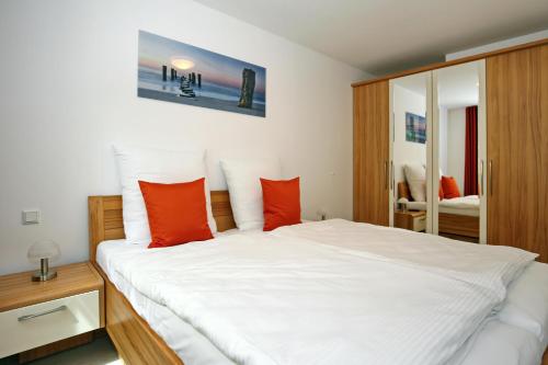 ハイリゲンダムにあるLinden-Palais Wohnung 13のベッドルーム(赤い枕の大きな白いベッド付)