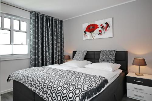ハイリゲンダムにあるLinden-Palais Wohnung 23のベッドルーム(白黒のベッド1台、窓付)