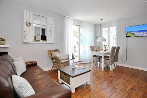 a living room with a couch and a table at Villa Seeadler Wohnung 07 in Börgerende-Rethwisch