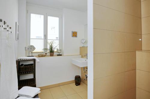 a white bathroom with a sink and a shower at Villa Seeadler Wohnung 07 in Börgerende-Rethwisch