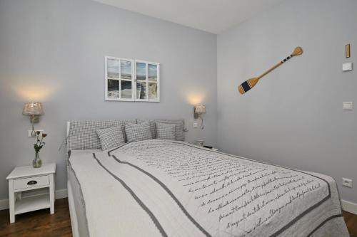a white bedroom with a bed and a window at Villa Seeadler Wohnung 07 in Börgerende-Rethwisch