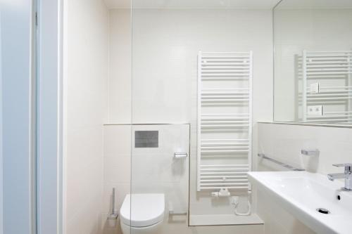 a white bathroom with a toilet and a sink at Linden-Palais Wohnung 10 in Heiligendamm