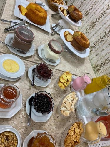 a table topped with plates of food and desserts at Cajazeiras Comfort Hotel in Cajazeiras