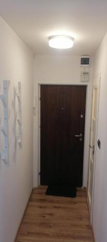 a black door in a room with a wooden floor at Studio Park Saski 1 & 2 in Sandomierz
