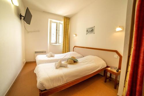 sypialnia z 2 łóżkami i ręcznikami w obiekcie Le Rabuons w mieście Saint-Étienne-de-Tinée