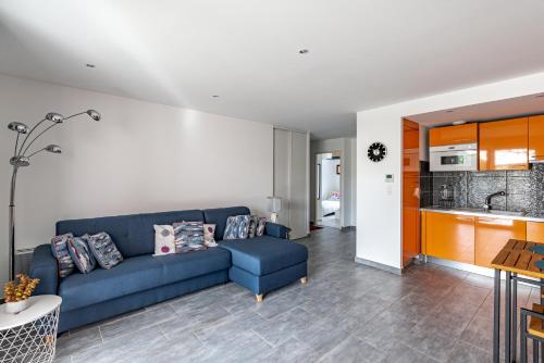 un salon avec un canapé bleu et une cuisine dans l'établissement Paoli, à LʼÎle-Rousse