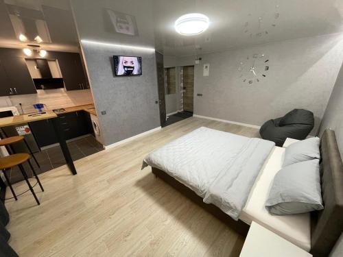 um quarto com uma cama branca e uma cozinha em Апартаменты VIP в центре города. Гагарина 39 em Krivoy Rog