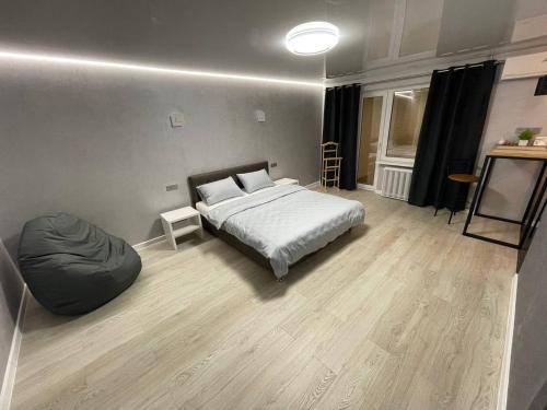 1 dormitorio con 1 cama y 1 silla con bolsa de frijoles en Апартаменты VIP в центре города. Гагарина 39, en Krivoy Rog