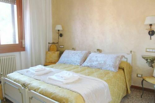 威尼斯的住宿－The Golden Apartment，一间卧室配有带毛巾的床
