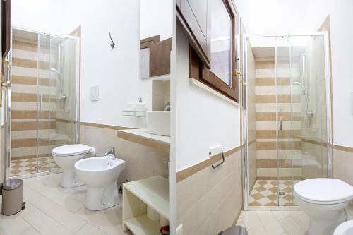 ein Badezimmer mit 2 WCs, einem Waschbecken und einer Dusche in der Unterkunft Case di Maria in Castellammare del Golfo