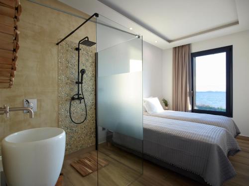 ein Bad mit einer Dusche, einem Bett und einer Badewanne in der Unterkunft Sereno Natu Villas in Skyros