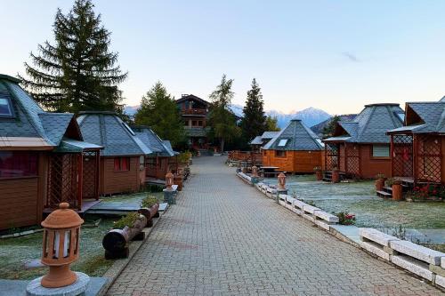 a cobblestone street in a village with wooden houses at DalaiLama Village in Antey-Saint-André
