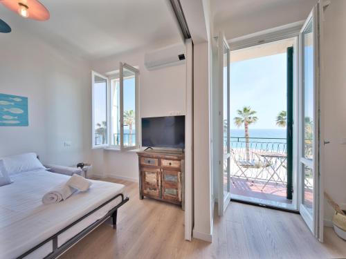 a bedroom with a bed and a view of the ocean at Medusa Apartment - Lungomare in Finale Ligure