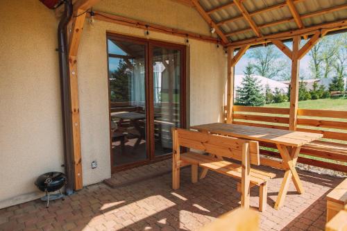 a wooden picnic table on the porch of a house at Leśna Oaza in Sasino