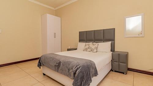 a bedroom with a large bed and a window at See You There Accommodation 1 in Centurion