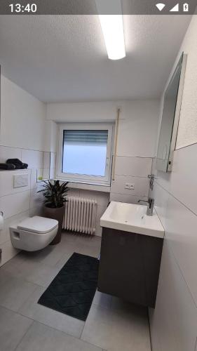 baño con lavabo y aseo y ventana en Ferienwohnung Maurer, en Bad Überkingen