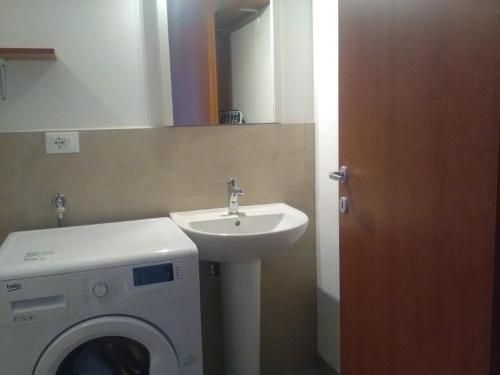 une salle de bains avec lave-linge et lavabo dans l'établissement VILLA MONICA Diano San Pietro (IM) Italy, à Diano San Pietro