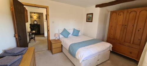 a bedroom with a bed with blue pillows at Greave farmhouse 3-Bed Cottage in Todmorden in Todmorden
