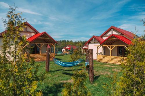 a couple of cottages with hammocks in the yard at Leśna Oaza in Sasino