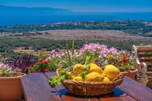 a basket of fruit sitting on a table with flowers at Saint George Castle Villa with sea view in Kefallonia