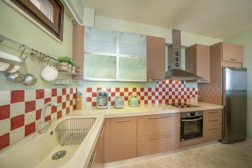 a kitchen with red and white tiles on the wall at Saint George Castle Villa with sea view in Kefallonia