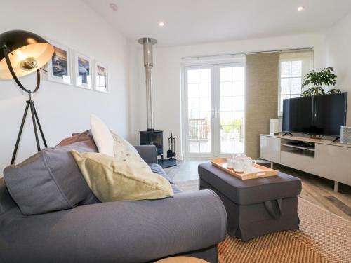 a living room with a couch and a tv at Badgers Way in Tintagel