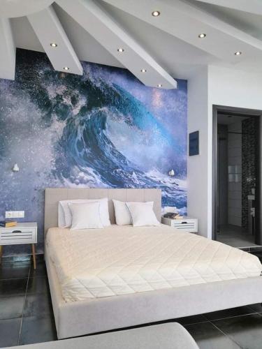 a bedroom with a large bed with a painting on the wall at Hotel George suite 1 in Limenas