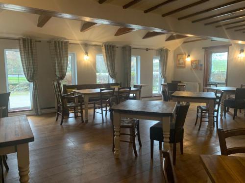 a restaurant with wooden tables and chairs and windows at The Sun Inn in Penrith