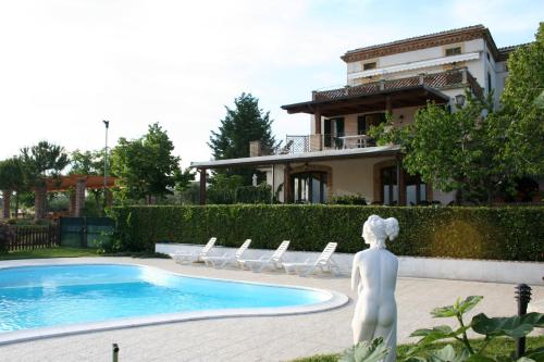 una estatua frente a una casa con piscina en Agriturismo Villa Fiore, en Torano Nuovo