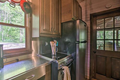 cocina con nevera de acero inoxidable y ventana en Romantic Log Cabin Escape on Delfosse Winery! en Faber