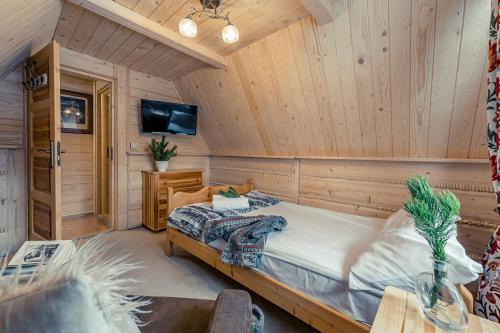 a bedroom with a bed in a room with wooden walls at Apartamenty Truchanówka przy Dolinie Chochołowskiej in Witów