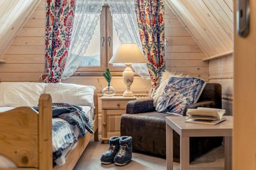 a bedroom with a bed and a couch and a table at Apartamenty Truchanówka przy Dolinie Chochołowskiej in Witów