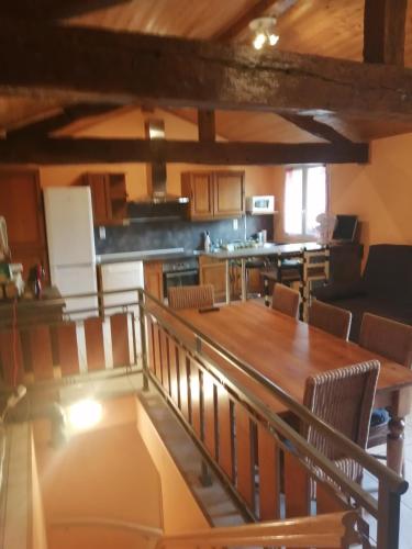 une cuisine et une salle à manger avec une table et des chaises en bois dans l'établissement petite maison de village loustalou, à Saint-Antonin-de-Lacalm