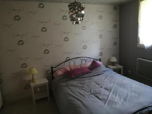 a bedroom with a bed with writing on the wall at petite maison de village loustalou in Saint-Antonin-de-Lacalm