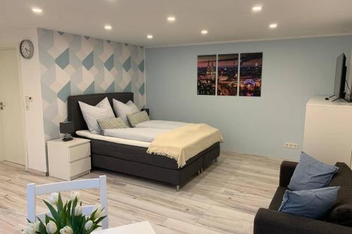 a bedroom with a bed and a couch at Modern renovated apartment suited for business consultants in close distance to DT, DHL and UN Campus in Bonn