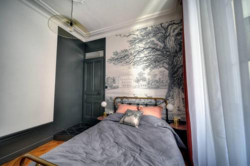 een slaapkamer met een bed met een schilderij aan de muur bij La Suite en Rose - Spa - Brotteaux in Lyon