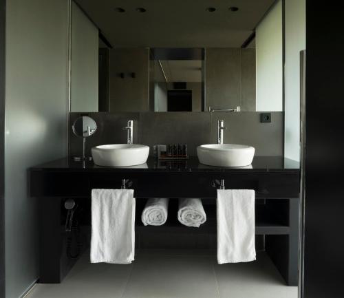 baño con 2 lavabos y espejo grande en VIVOOD Landscape Hotel & Spa - Designed for Adults, en Benimantell