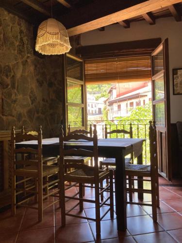 Casa rural Adelaida في Villanueva del Conde: غرفة طعام مع طاولة وكراسي ونافذة