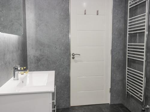 een witte badkamer met een wastafel en een spiegel bij Shore View in Burntisland