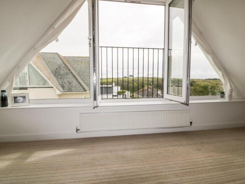an empty room with a large window and a wooden floor at Crabs and Lobsters in Newquay