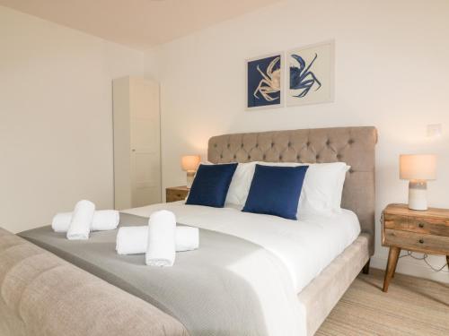 a bedroom with a large bed with blue and white pillows at Crabs and Lobsters in Newquay