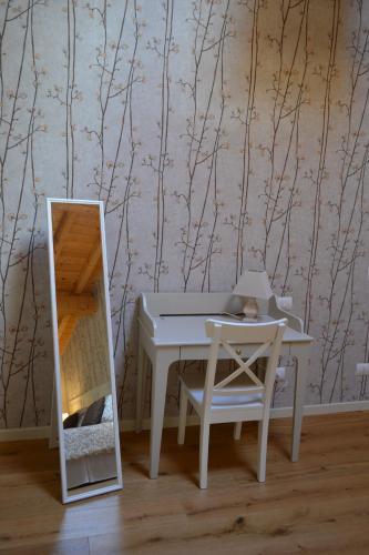 a table and a chair and a mirror in a room at La Locanda nel Frutteto in Rovereto